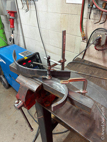 The bars are clamped to a piece of angle iron for welding